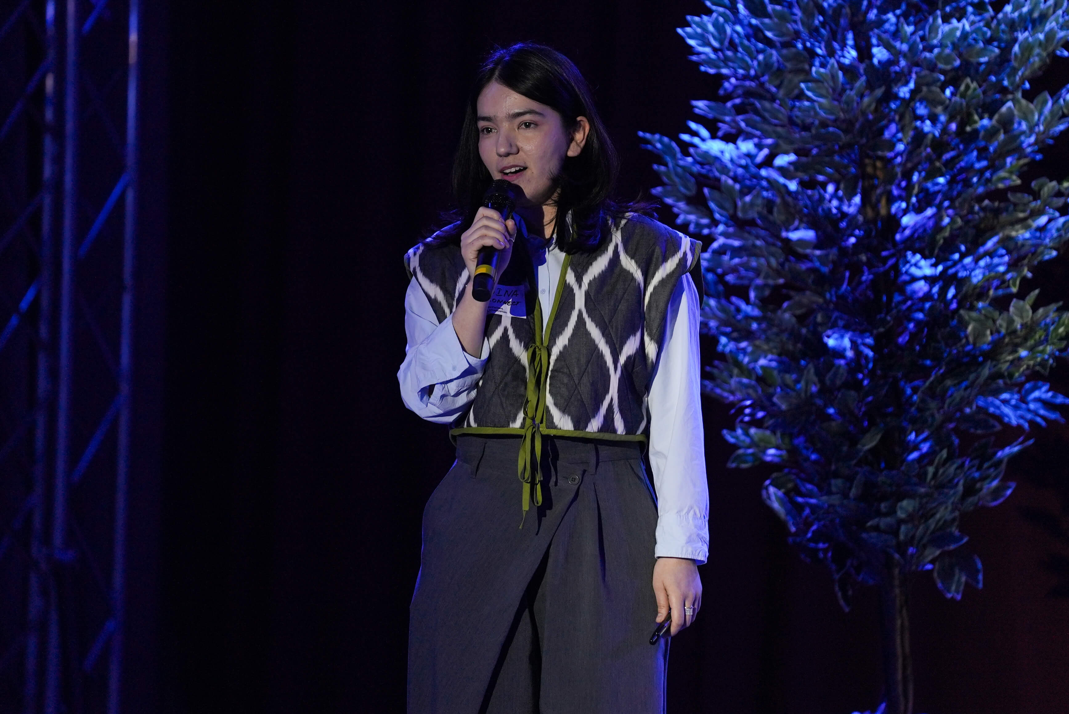 Close up of a speaker presenting on stage under bright lights